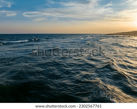 An aerial view over the calm waters of the Atlantic Ocean at sunset near the shore at Long Beach, New York.
