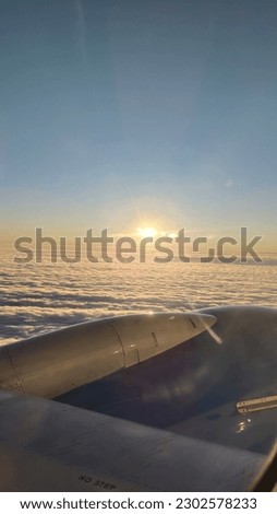 View from the window of an airplane at sunset and clouds below