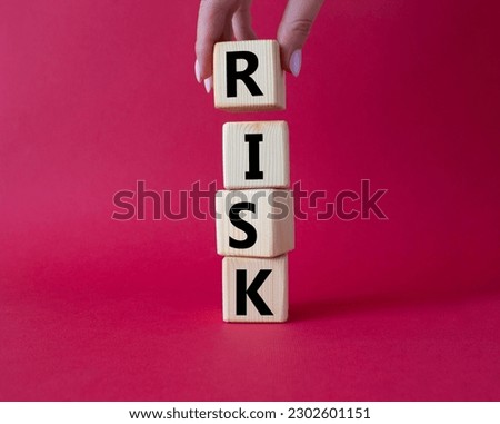 Risk symbol. Concept word Risk on wooden cubes. Businessman hand. Beautiful red background. Business and Risk concept. Copy space.