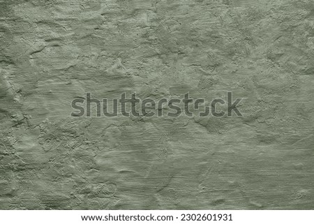 Dark sage green khaki wall texture background. Rough uneven surface. Close-up. Plaster, stucco, interior. Paint. Rough brush strokes. Vintage, antique, old, rustic.