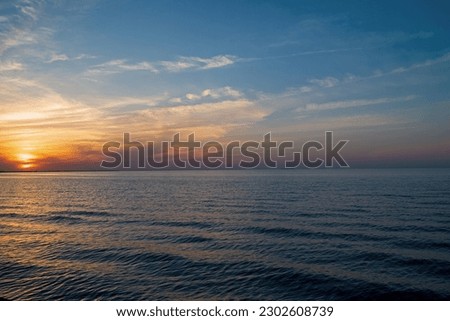 Lake Erie with shoreline at sunset. It is the fourth largest lake of the five Great Lakes in North America. At its deepest point it is 210 feet deep. Royalty-Free Stock Photo #2302608739