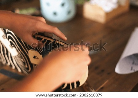 Middle Schooler boy applying grip tape to his skateboard. Royalty-Free Stock Photo #2302610879