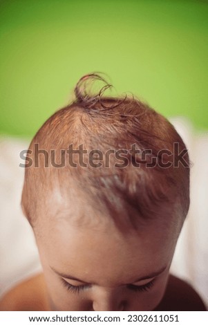 Focus on baby's curl on top of his head.