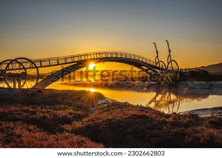 Autumnal and sunrise view of red glasswort on mud flat against Misaeng's Bridge and fog on the sea with tidal channel near Siheung-si, South Korea
 Royalty-Free Stock Photo #2302662803