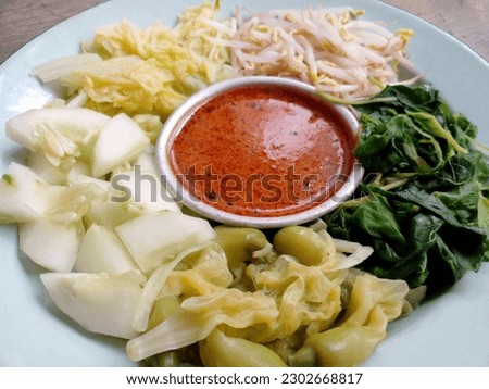 Pecel. In the form of several vegetables such as spinach, bean sprouts, cucumber, turi flowers and chicory mixed with peanut sauce. Boiled vegetables are placed on a plate. Indonesian food.