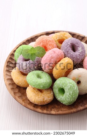 A snack shaped like a donut, colorful with a sweet and crisp taste