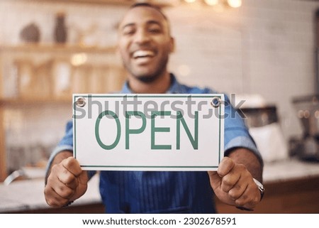 Open, sign and closeup of man in shop, store and advertising notice of retail shopping time, board or trading information. Hands of happy cafe owner with opening banner, welcome and startup services
