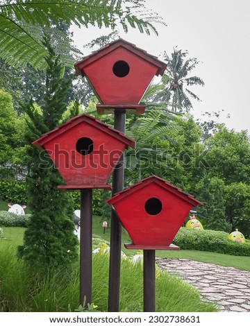 Three wooden bird cages in the garden