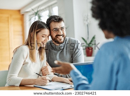 Real estate agent with couple closing a deal and signing a contract Royalty-Free Stock Photo #2302746421