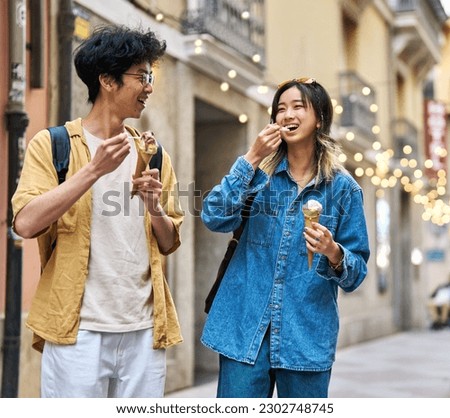 Portrait of a smiling couple in the city, tourists visiting destination, summer trip exploring and eating an ice cream Royalty-Free Stock Photo #2302748745