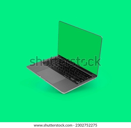 Photo of realistic modern laptop with blank green screen floating in front of a green background