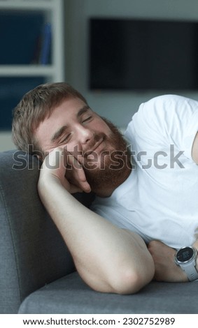 Sweet dreams. Serene millennial male lie on soft cozy couch in comfortable pose having tight sleep. Satisfied young guy nap on sofa at home enjoy good rest relax, man at living room at home 