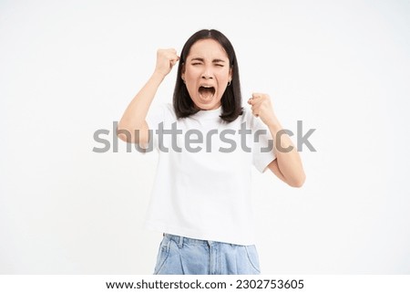 Angry korean woman, screaming and shouting, looking hurt and frustrated, shaking hands, standing over white background. Royalty-Free Stock Photo #2302753605