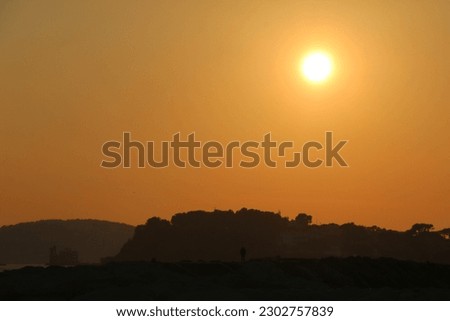 A photo of a golden sky of sunsetting at a beach
