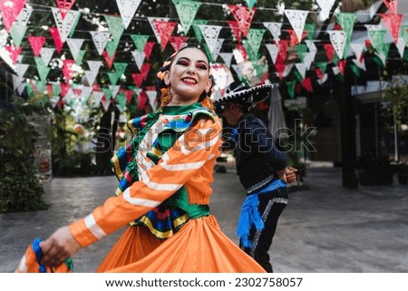 Latin couple of dancers wearing traditional Mexican dress from Guadalajara Jalisco Mexico Latin America, young hispanic woman and man in independence day or cinco de mayo parade or cultural Festival Royalty-Free Stock Photo #2302758057
