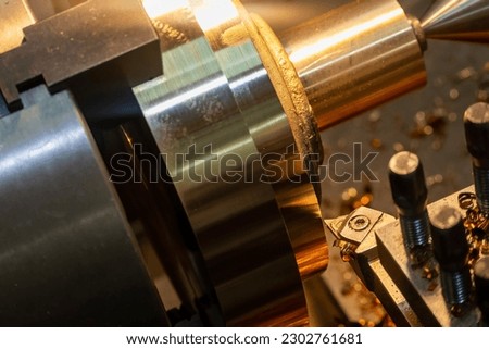 Closeup scene the lathe machine finish cut the brass parts by lathe tools. The metalworking process by turning machine.