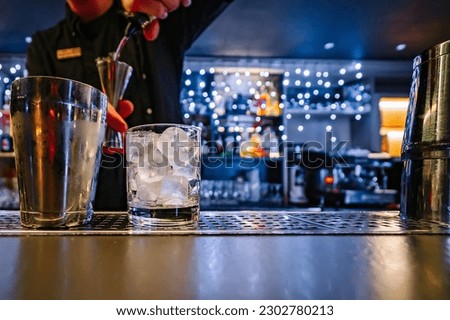 man hand bartender making cocktail in glass on the bar counter Royalty-Free Stock Photo #2302780213