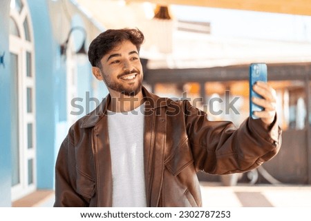 Handsome Arab man at outdoors making a selfie with mobile phone