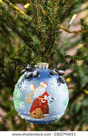 blue glass ball decorated of santa claus image on christmas tree close up indoor