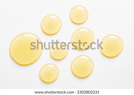 Yellow drops of gel close up. Cosmetic product for moisturizing the skin of the face or body. Royalty-Free Stock Photo #2302802231