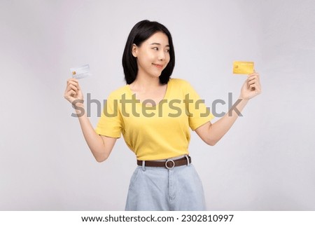 Young casual female paying with credit card, smiling happy fun on white background studio portrait.