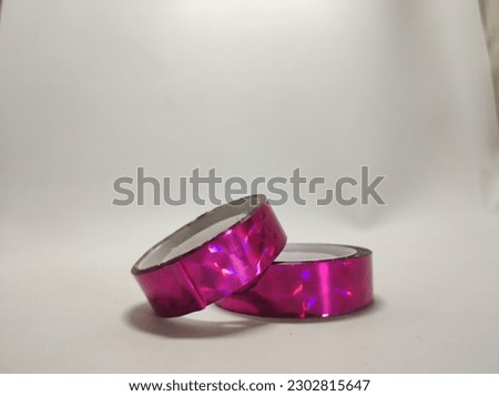 Selective Focus on small duct tape, shiny decoration, pink in color, versatile and multifunctional adhesive, for decoration as well as various things that need this tape, white background