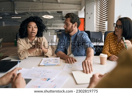 Group of multiracial business people, developers, coworkers talking, planning startup, cooperation, sharing ideas working together in modern office. Meeting, teamwork, successful business concept 