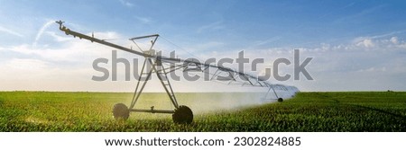 Irrigation system watering agricultural fields of corn in summer Royalty-Free Stock Photo #2302824885