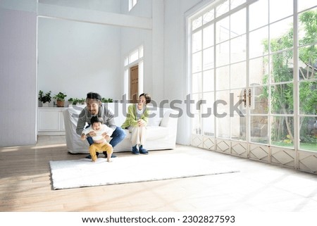 Friendly family playing with toddler in living room Copy space available wide angle Royalty-Free Stock Photo #2302827593