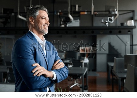 Happy proud prosperous mid aged mature professional business man ceo executive wearing suit standing in office arms crossed looking away thinking of success, leadership, side profile view. Royalty-Free Stock Photo #2302831123
