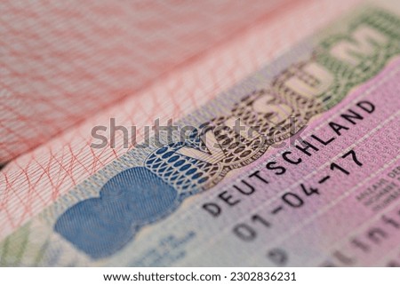close-up part of page of document, foreign passport for travel with German visa, tourist schengen visa stamp with hologram with shallow depth of field, passport control at border, travel in Europe
