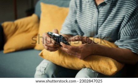 Beautiful elderly woman smile using mobile phone enjoy playing social media checking email. Happy attractive grandma hand holding smartphone scrolling looking at screen sit on sofa in living room Royalty-Free Stock Photo #2302847025