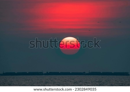 The big red sun was setting on the horizon at dusk. Royalty-Free Stock Photo #2302849035