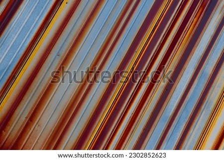 Close-up. Old rusty corrugated sheet. Coloured striped background. Royalty-Free Stock Photo #2302852623