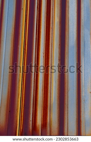 Close-up. Old rusty corrugated sheet. Coloured striped background. Royalty-Free Stock Photo #2302853663