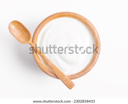 Fresh greek yogurt in wooden bowl with wooden spoon on white background. Healthy breakfast.