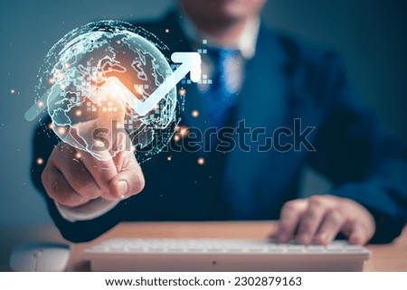 Businessman touching the virtual reality globe and rising bar chart graph as holographic button. Business people and Innovative technology concept.