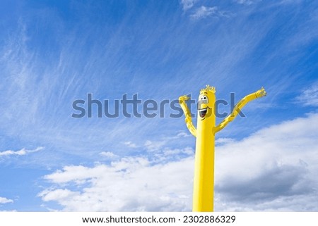 Yellow Inflatable Doll Blowing Wind with happy face. Royalty-Free Stock Photo #2302886329