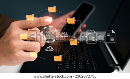 An IT specialist is configuring a Document Management System (DMS) on a laptop at the office. program for archiving company files Royalty-Free Stock Photo #2302892735