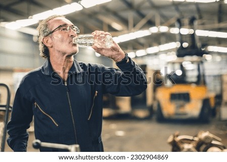 Thirsty senior male staff worker drinking water refreshing from tired hard work in hot workplace Royalty-Free Stock Photo #2302904869