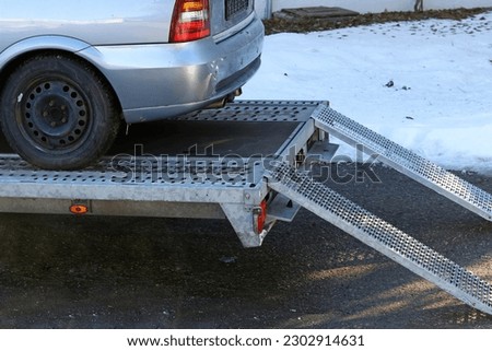 An older car was loaded onto a trailer Royalty-Free Stock Photo #2302914631