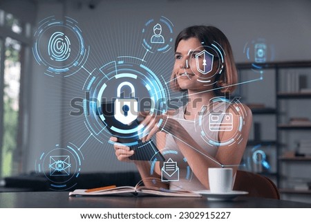 Smiling businesswoman in casual wear holding tablet device touching it at office workplace. Concept of distant work, business education, information technology. Lock icons hologram