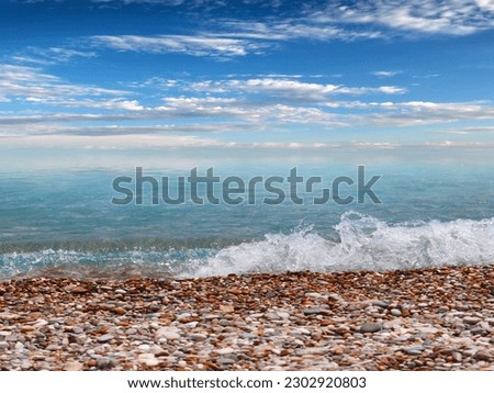 beautiful sunny sky over pebble sea beach with waves