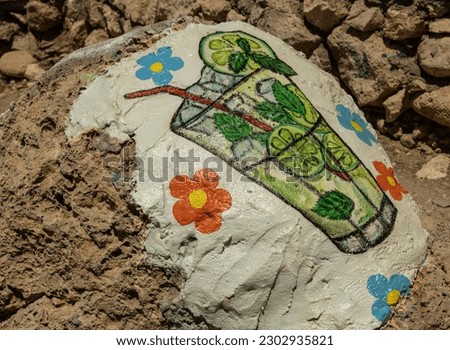 Image of a glass with a mojito cocktail on a stone near a bar on Red Beach, Greece, Crete, Matala