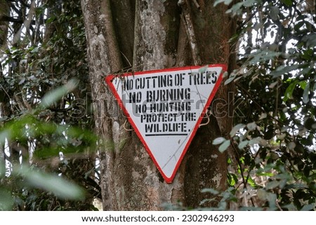 Sign in the forest - no cutting trees, no burning, no hunting to protect wildlife