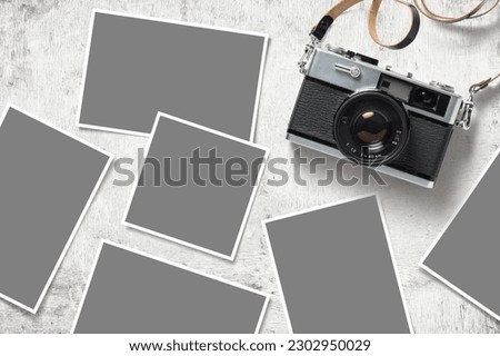 photo mockup or template with vintage analog camera and paper prints images scattered on a white wooden table, top view, flat lay