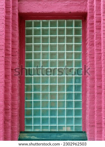 Square glass block window in pink brick wall