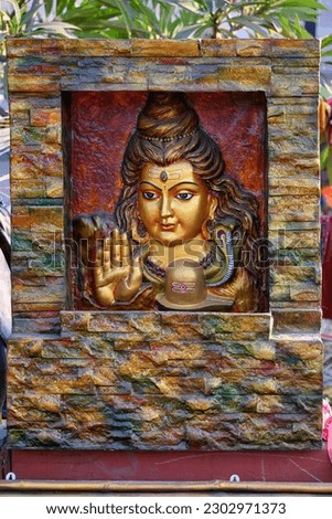 Beautiful handmade sculpture of Lord Shiva is displayed in a shop for sale in blurred background. Indian art and handicraft. Royalty-Free Stock Photo #2302971373