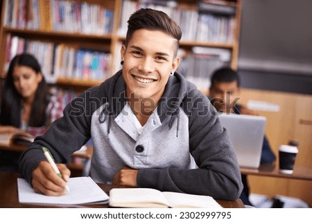 Education, writing and happy with portrait of man in library for study, research or classroom quiz. Focus, learning and notebook with male student at university for knowledge, scholarship and project