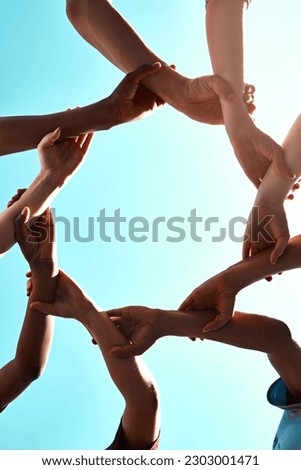Hands, link and circle with team and blue sky with low angle, solidarity and trust with arm chain and people together. Teamwork, motivation and connection with group collaboration and community Royalty-Free Stock Photo #2303001471
